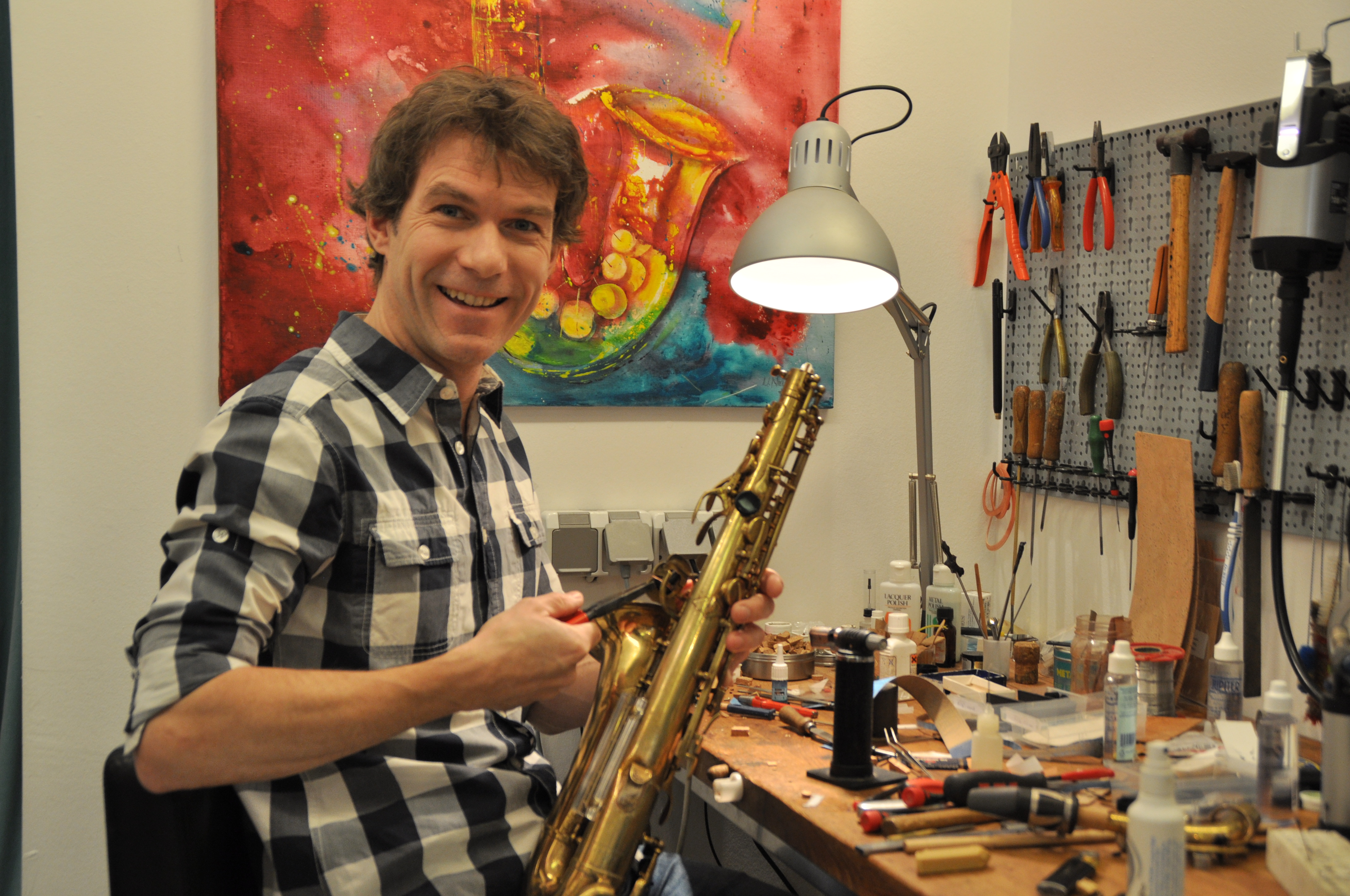 Matthias Rüdiger bei der Arbeit an einem Saxophon an seiner Werkbank in der Musikwerkstatt Hofheim